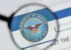 Magnifying glass over Department of Defense logo.
