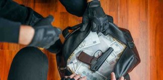 Fort Stewart: Shooter Alert Issued Gloved hands around bag with money and gun.