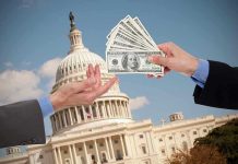 Hands exchanging money in front of Capitol building.