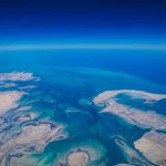 America’s Secret Wealth EXPOSED! Aerial view of coastline and ocean.