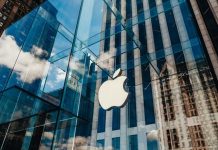 Apple Phishing Scam: Trust Shattered! Apple store with glass facade and city reflections.