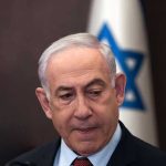 Mamdani vs. Netanyahu: Tensions Explode Man in suit with Israeli flag in background.