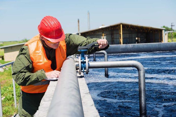 Worker in safety gear inspecting water treatment equipment
