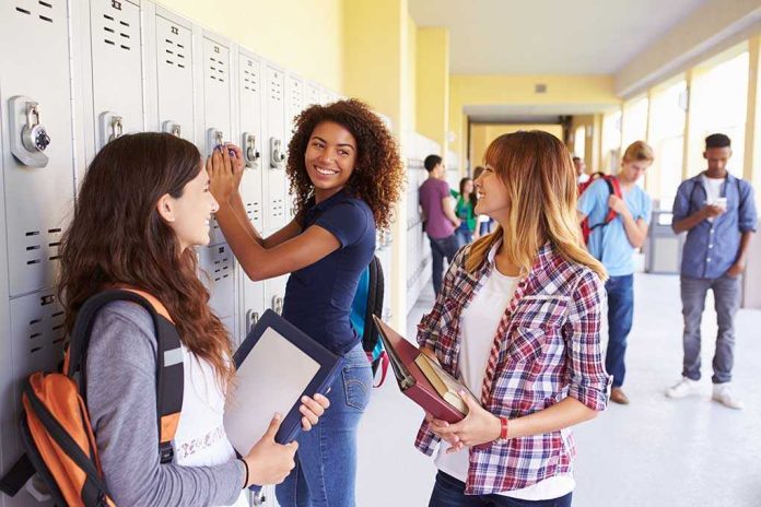 shutterstock_199302515.jpg Three high school students interacting near lockers in a hallway