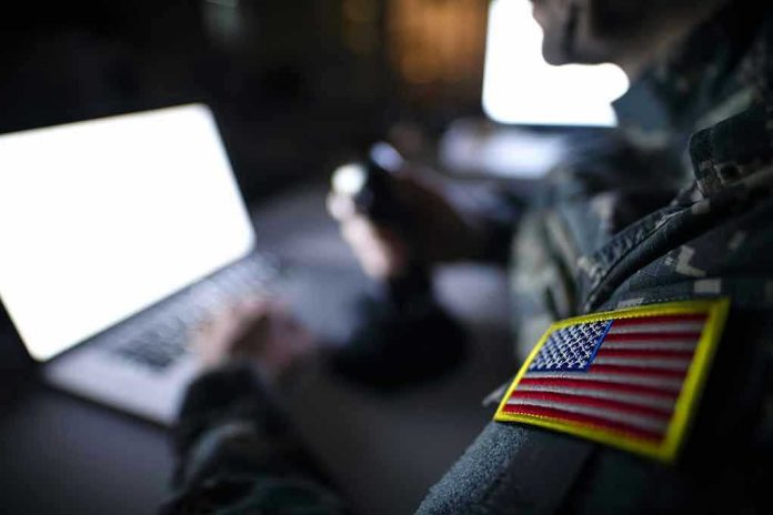 1395036650 Soldier using laptop with US flag patch visible.