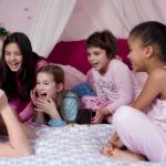 Group of children laughing and enjoying a sleepover in a cozy bedroom