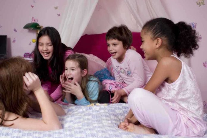 Group of children laughing and enjoying a sleepover in a cozy bedroom
