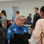 Airport NIGHTMARE: Democrats Block Homeland Security Budget TSA agent checks passengers documents at airport security.