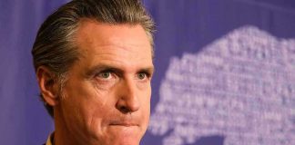 Resurfaced Clip IGNITES Newsom Culture War Man in suit, solemn expression, purple background with bear drawing.