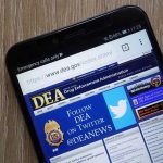 Your App Data: New Government Grab? DEA website open on smartphone screen.