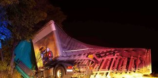 Drug-Driven Crash KILLS Three—Illegal Trucker Cuffed An overturned truck on the side of the road at night with emergency lights