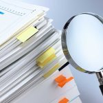 Word Games Rewrite Pregnancy Law? Stack of documents with a magnifying glass beside it