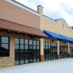 Grocery Closures CRIPPLE Baltimore – Why Now? Exterior view of a commercial building with blue awnings and large glass windows