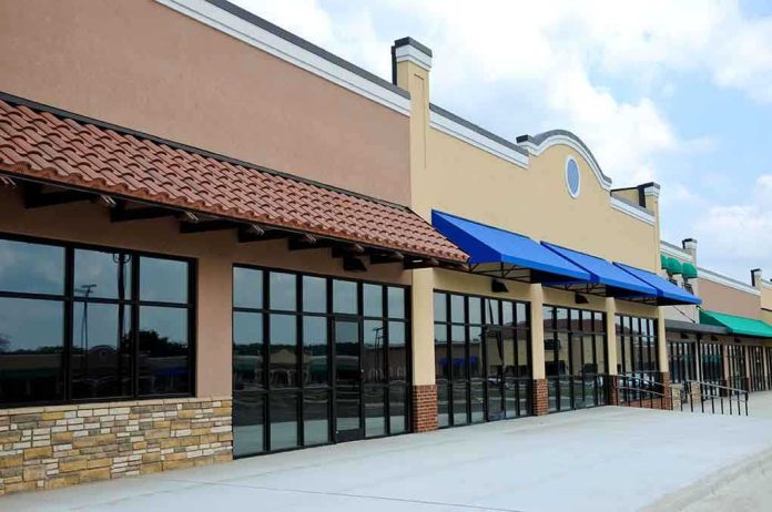 shutterstock_37407268 Exterior view of a commercial building with blue awnings and large glass windows