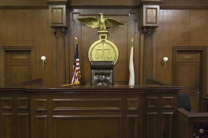Judges bench in an empty courtroom, scales emblem above.