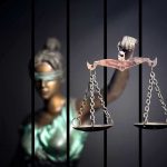 Supreme Court Catches Krasner’s Office Misleading Judges Blindfolded Lady Justice statue holding scales behind bars.