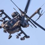 Iran Blamed — Trump Vows Payback An Apache helicopter flying in the sky with visible rotor blades