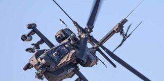 Iran Blamed — Trump Vows Payback An Apache helicopter flying in the sky with visible rotor blades