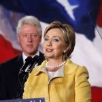 Clinton Breaks With Her Own Party On Trump Hillary Clinton speaking at a podium with Bill Clinton in the background