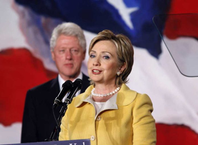shutterstock_3975055 Hillary Clinton speaking at a podium with Bill Clinton in the background