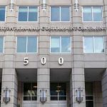 DOJ Targets Passports — 250 Cases Coming US Immigration and Customs Enforcement building entrance flags