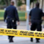 Pelosi Crash Mystery Deepens Police officers walking past caution tape at a crime scene