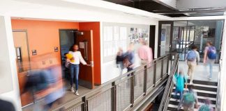 Students walking through a modern school hallway and stairwell