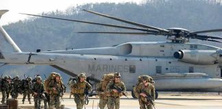 Iran Missiles Kill Americans — One Missing Soldiers disembark and walk past a large military helicopter