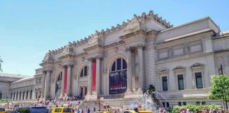 Grand museum facade with columns and busy street with taxis