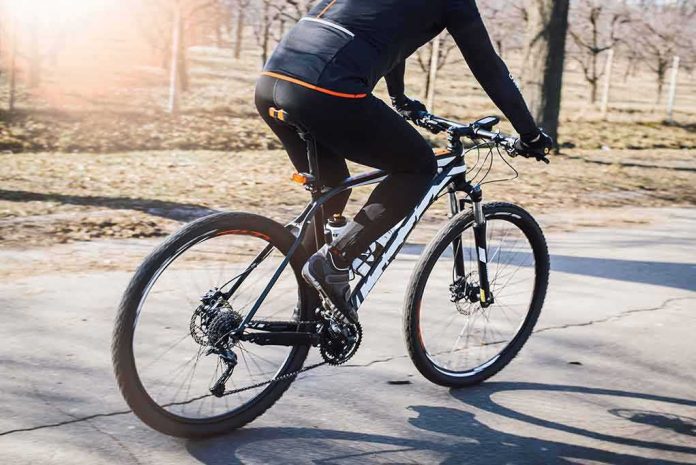 cyclist riding a mountain bike on a paved path