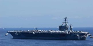 5,000 Sailors Arrive — Thailand Braces Aircraft carrier at sea with crew lining the deck