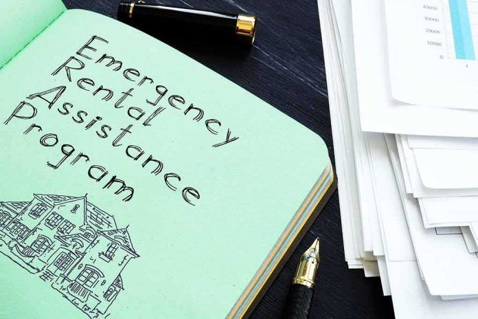 Notebook titled Emergency Rental Assistance Program beside papers and pen