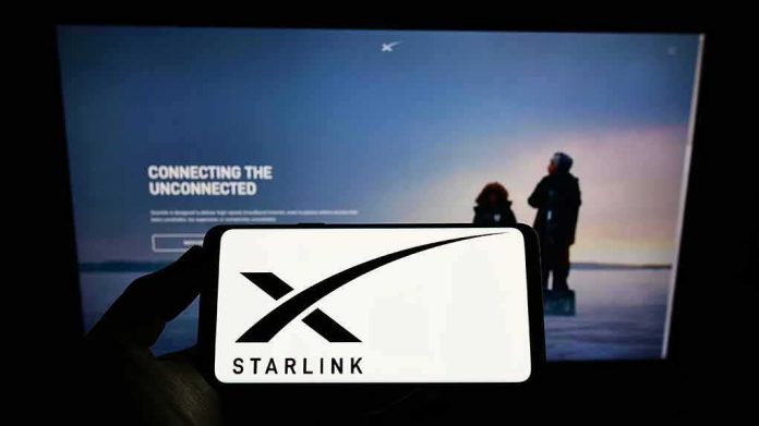 Smartphone showing Starlink logo in front of a computer screen