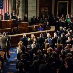Legislators give a standing ovation in a grand chamber