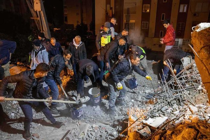 shutterstock_2258811655 Rescue workers search through rubble at night