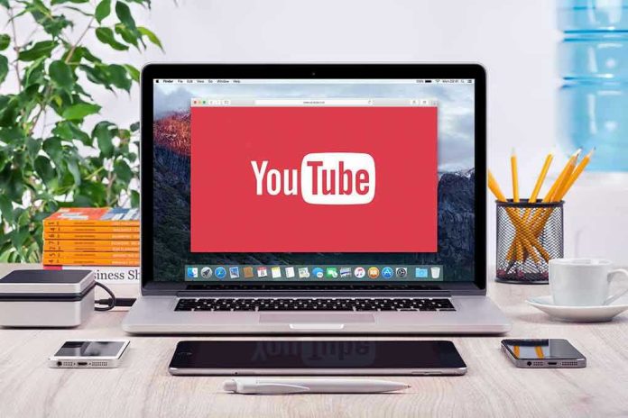 293731811 YouTube logo on a laptop screen on desk.