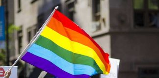 Kim Kyung-tae with others waving a rainbow pride flag at a street parade