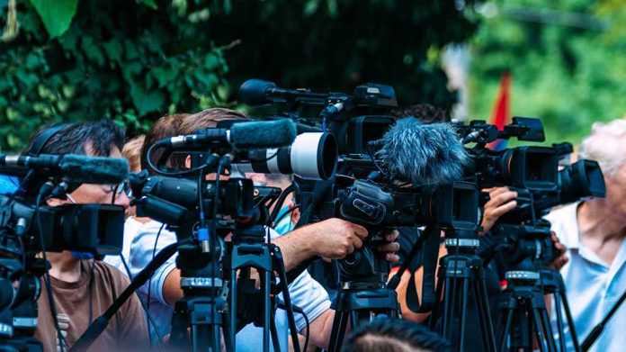 default-hero-03-1 TV news cameras crowding together at an outdoor event