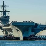 ‘How Weak Are You?’ Double-Amputee Vet Rips Navy Sailors Aircraft carrier guided by tugboats in a harbor