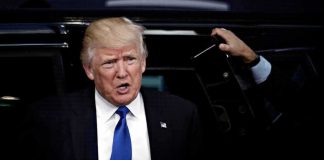 Donald Trump stepping out of a vehicle in a suit and blue tie