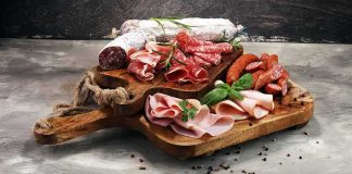 Charcuterie board with assorted cured meats and herbs