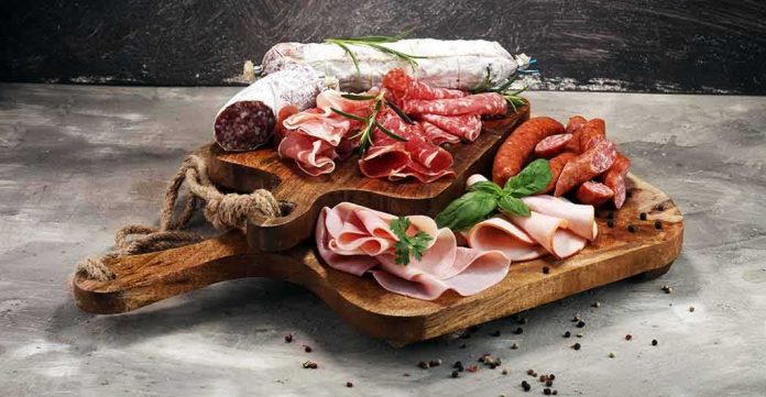 shutterstock_1083582977 Charcuterie board with assorted cured meats and herbs