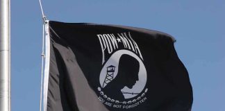 Captured Navy Pilot Made a Defiant Choice Under Torture POW MIA flag waving against a blue sky