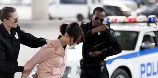 AI Match Put Grandmother Behind Bars for Months Police officers detain a woman beside a patrol car