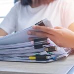 CIA Warnings Ignored? 9/11 Files Drop Person organizing a stack of documents with binder clips