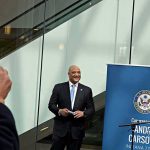Bongino vs. Massie: Epic Showdown Over Epstein Files Man in a suit at a public event near a blue banner