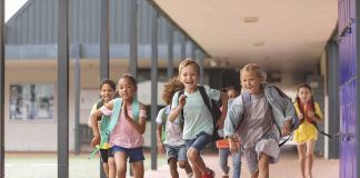 Group of schoolchildren running down a hallway