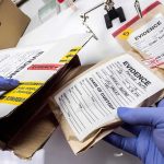 Accused Child-Killer Asks Judge to Set Her FREE Gloved hands handling labeled evidence bags and boxes