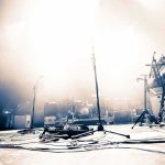 Tour Bus Death Halts Rock Show Empty concert stage with instruments and bright lights