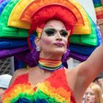 Drag Queen Opener Ignites Portland Schools Firestorm Drag performer in vibrant rainbow costume at a parade